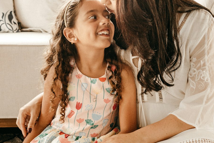 A mother and daughter sitting close and smiling at each other