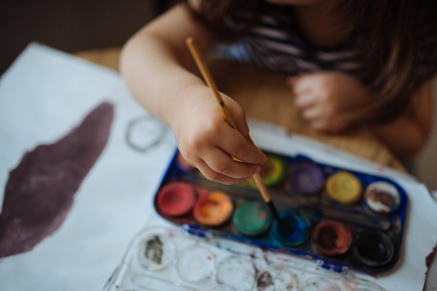 A child painting with watercolours on paper